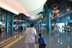 You are in a Great Hall, beneath the Saturn V. It does not seem real. Even when you are looking directly at it from close range. But it is. It is real. And what it did was real, too.